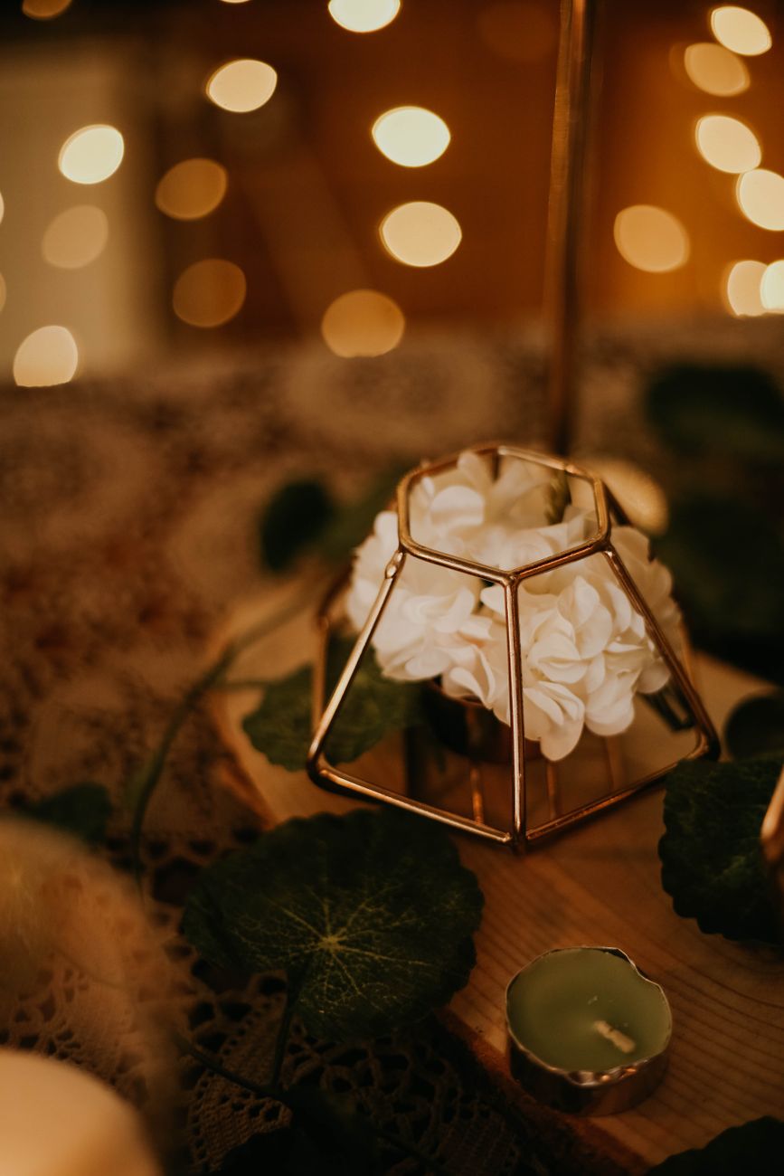 A cozy floral centerpiece framed by warm bokeh lights, perfect for romantic settings.