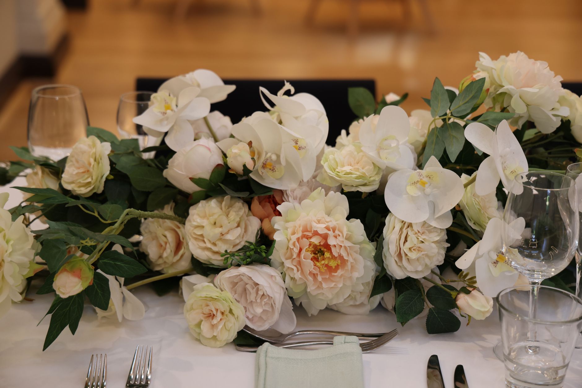 Exquisite table arrangement with peonies and orchids, perfect for weddings.